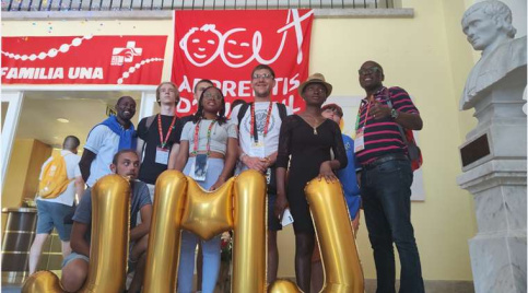 Un groupe de jeunes et de spiritains se tient devant le drapeau Apprentis d'Auteuil