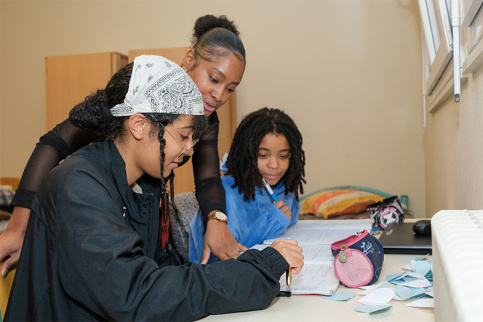 Nathanaël Pitard, éducatrice, aide Lola et une autre jeune fille à faire leurs devoirs dans leur chambre à l'internat éducatif et scolaire