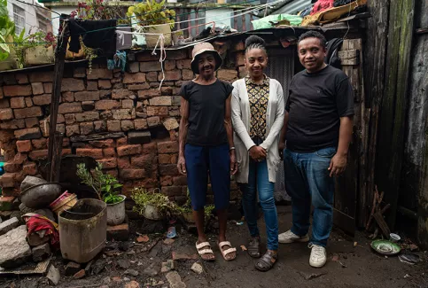  Association Graines de Bitume à Madagascar - Mampionona devant chez elle, avec sa maman et Hery Randrianarisoa, responsable du programme pédagogique et de l'animation 