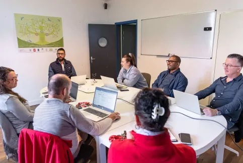 6 personnes assises dans une salle de réunion