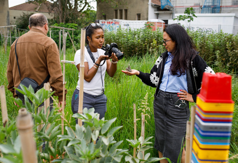Maison des familles de Villeurbanne, Besma lors d'un atelier photos sur le thème du jardin, avec Christophe, photographe intervenant, et Séverine, une collaboratrice