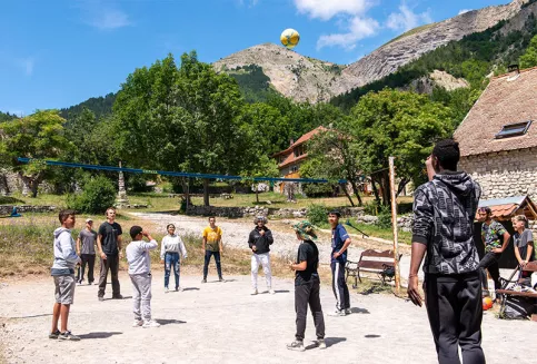 Partie de volley-ball entre des jeunes de la MECS La Valbourdine et du partenaire colombien Oasis by Fondacio au hameau de Vaunières lors d'un AESI de réciprocité