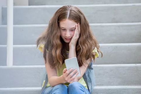 Jeune fille faisant un selfie assise sur des marches