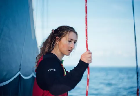 Violette Dorange tenant un boot sur son bateau