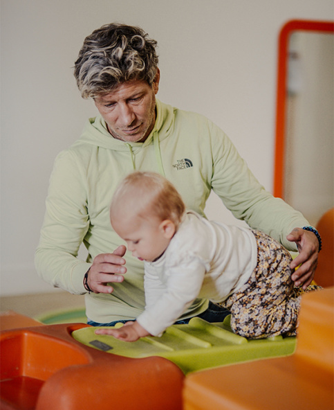 Crèche Les petites pousses du lac - Un atelier de motricité avec David Cunego, auxiliaire de puériculture, qui assure la sécurite d'Ambre tout en la laissant faire.