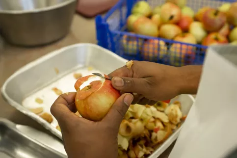 Les mains d'une personne épluchant une pomme