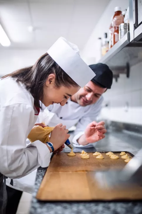 Deux cuisiniers en train de préparer des desserts