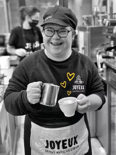 jeune homme souriant préparant un café au lait
