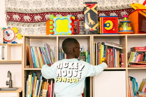 Maison des familles de Bordeaux - Dans le coin enfants, Mohan devant la bibliothèque