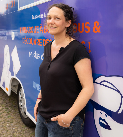 Jeune femme adossée à un bus bleu