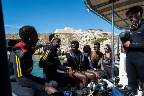 Jeunes hommes sur un canot en mer