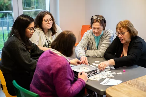 Maison des familles de Montdidier, Amandine (service civique) à gauche joue avec des bénéficiaires et des bénévoles 