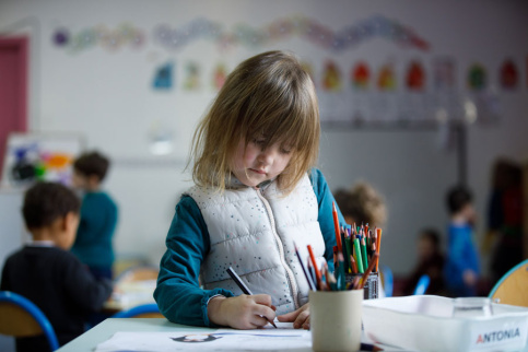 petite fille dessinant sur son bureau