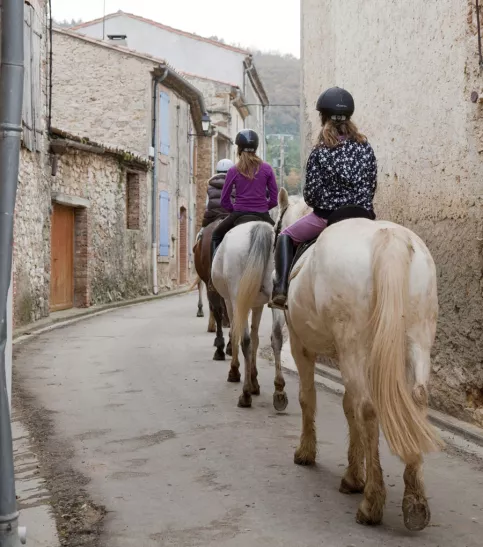 jeunes cavalières en promenade dans une rue d'un village
