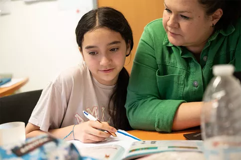 Enfant de la MECS Saint-François d'Assise de Strasbourg faisant ses devoirs avec une éducatrice