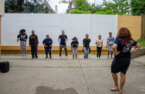 AESI - Groupe de jeunes jouant à un jeu de rapidité dans la cour en musique (