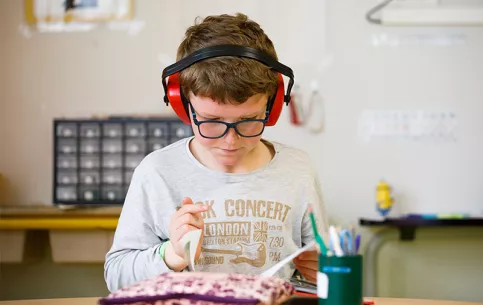 Ecole Frassati (site de Saint-Cyr) - Martin se met au calme pour lire avec un casque sur les oreilles 