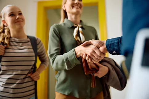 Une maman et sa fille rencontrent un professeur au sein de l'école