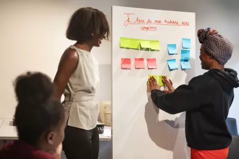 jeune fille à côté d'un tableau avec des post-it