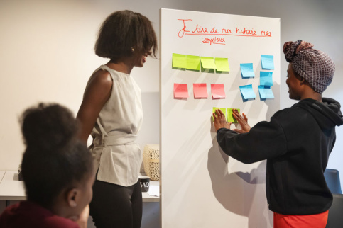 jeune fille à côté d'un tableau avec des post-it