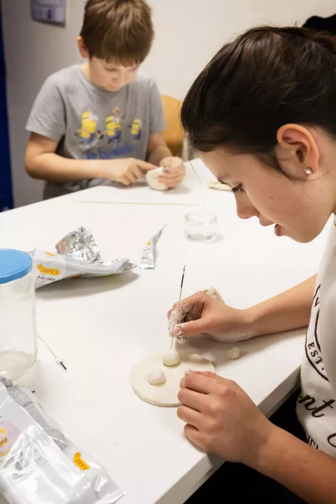 une collègienne qui fait de la pâte à modeler