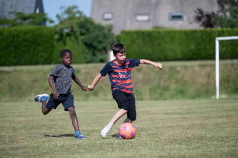 2 garçons jouent au foot