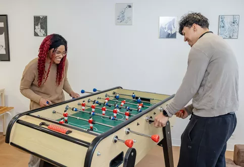Miléna, ancienne de la RSOE de Toulon joue au baby-foot avec Coroni un résident actuel.