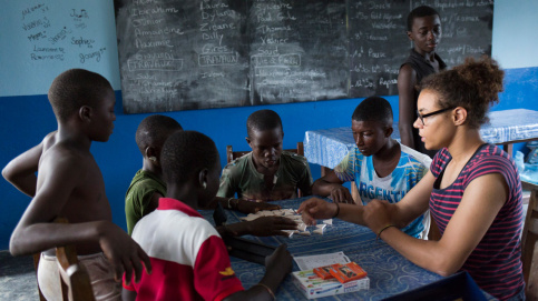 Amandine fait un jeu de société avec des jeunes du foyer. Photo : P. Besnard