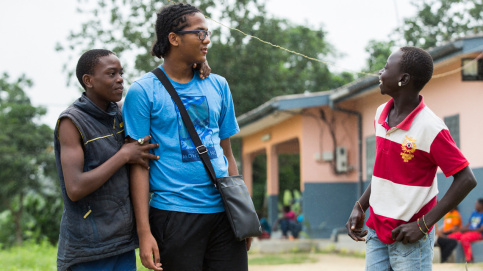 La pluie n’empêche pas la complicité entre Akim et 2 jeunes Camerounais. Photo : P. Besnard