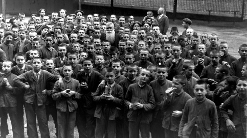 Le père Brottier entouré par les jeunes à l'heure du goûter (c) Archives historiques / Apprentis d'Auteuil