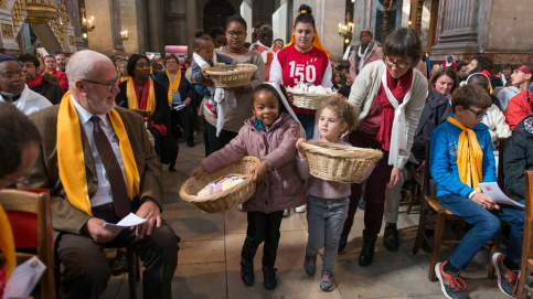 Des enfants apportent les corbeilles remplies des intentions de prière confiées par les donateurs et amis d'Apprentis d'Auteuil.