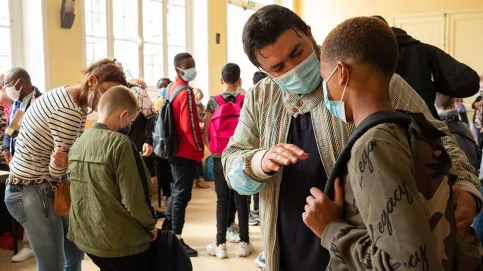 Encouragé par un parent ou un éducateur, chaque élève écoute les dernières consignes avant de monter en classe. 