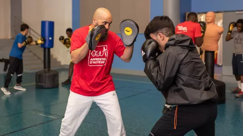 Tarik apprend à Baran, jeune accompagné par la Maison d'enfants Sainte-Thérèse, à perfectionner sa technique. (c) Ilan Deutsch/Apprentis d'Auteuil