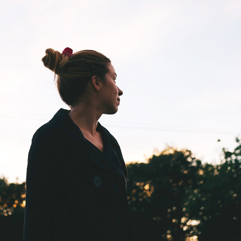 Jeune femme regardant le ciel, lumière de fin de journée