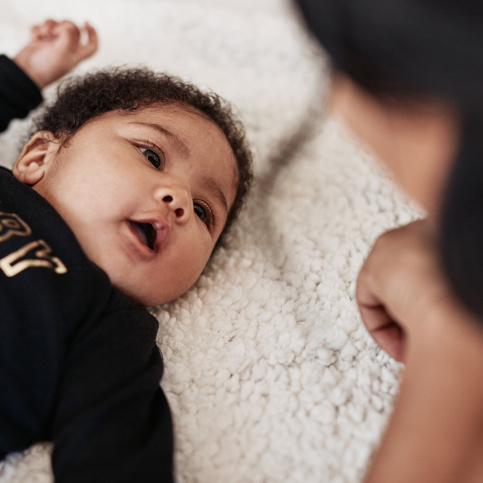 Photo d'une bébé allongé regardant sa maman