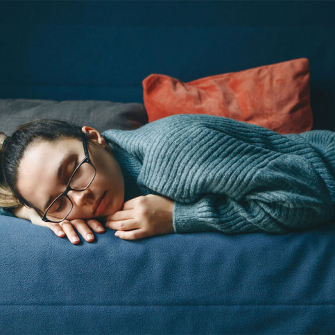 Illustration de la fatigue chez les jeunes, jeune fille dormant sur un canapé