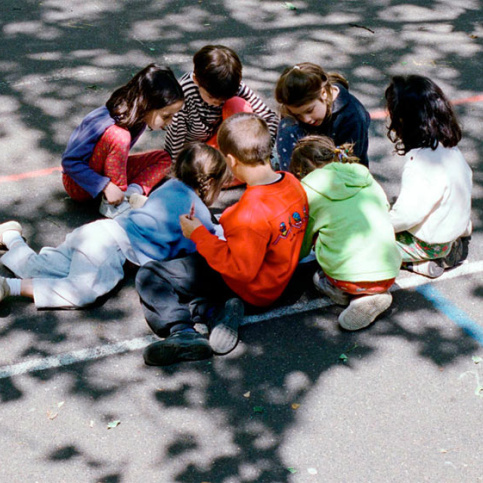 groupe d'enfants assis dans la cour de récréation