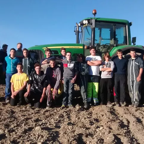 Des élèves du Lycée professionnel agricole Val de Drôme posent dans un champ devant un tracteur