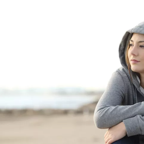 Jeune fille sur la plage, pensive