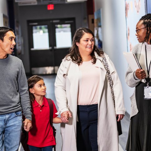 Des parents avec leur enfant rencontre une professeur au sein de l'école 