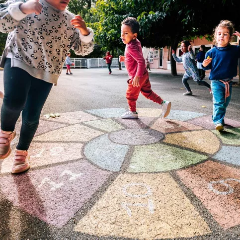 Elèves dans une cour de récréation jouant à la marelle 
