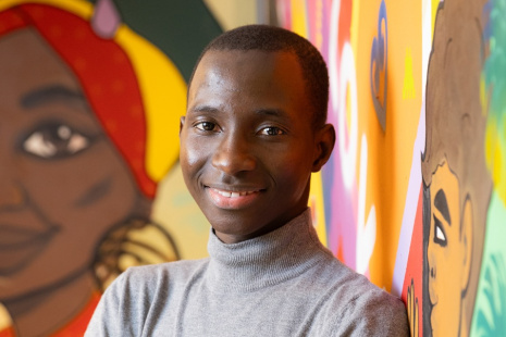Jeune garçon souriant devant une fresque murale