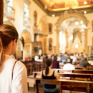 Jeune femme, de dos, entrant dans une église 