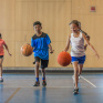 Elèves jouant au basket dans un gymnase