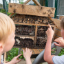 Ecologie intégrale - Deux enfants devant un hôtel à insectes