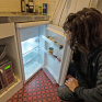 Jeune homme dans sa cuisine, devant son frigo presque vide 