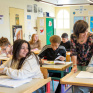 Salle de classe au collège Saint-François du Château des Vaux avec des jeunes et un professeur.